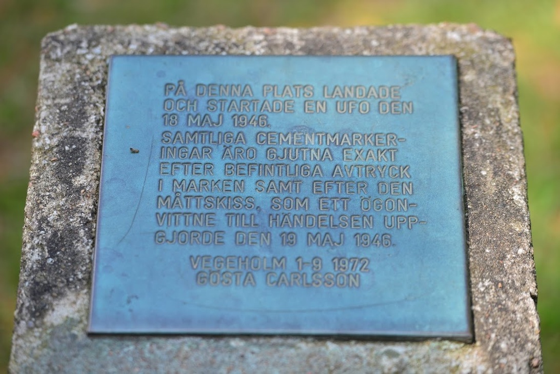 En blå minnesplakett på en stengrund.